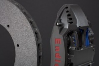 Studio image of metallic brake caliper and ceramic composite rotor